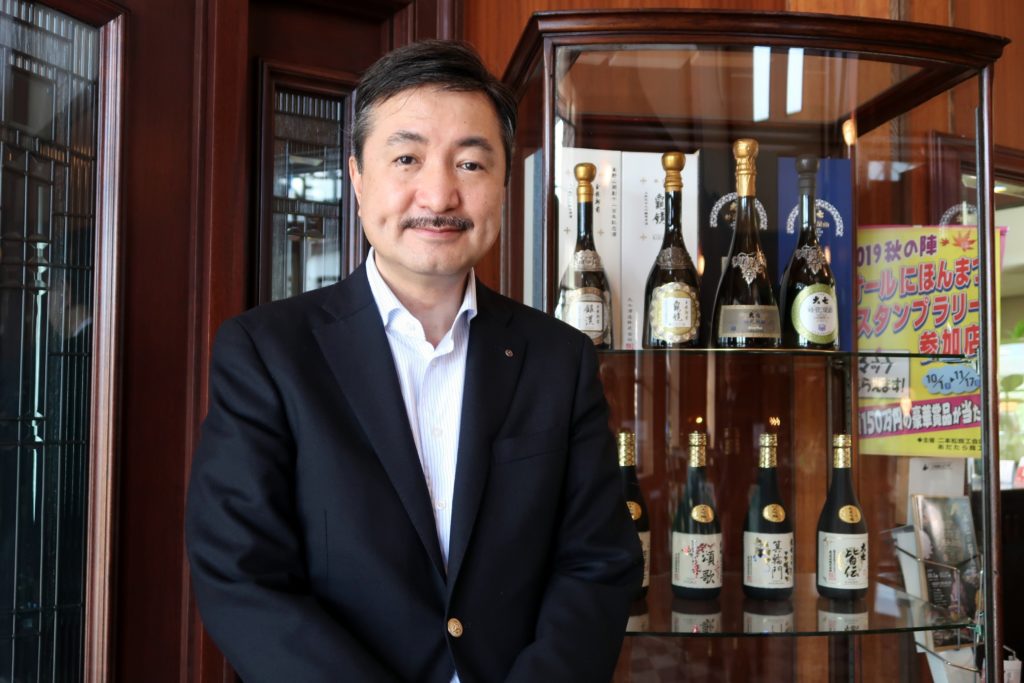 Hideharu Ohta, 10th-generation owner of Daishichi sake brewery, stands in front of award-winning sake